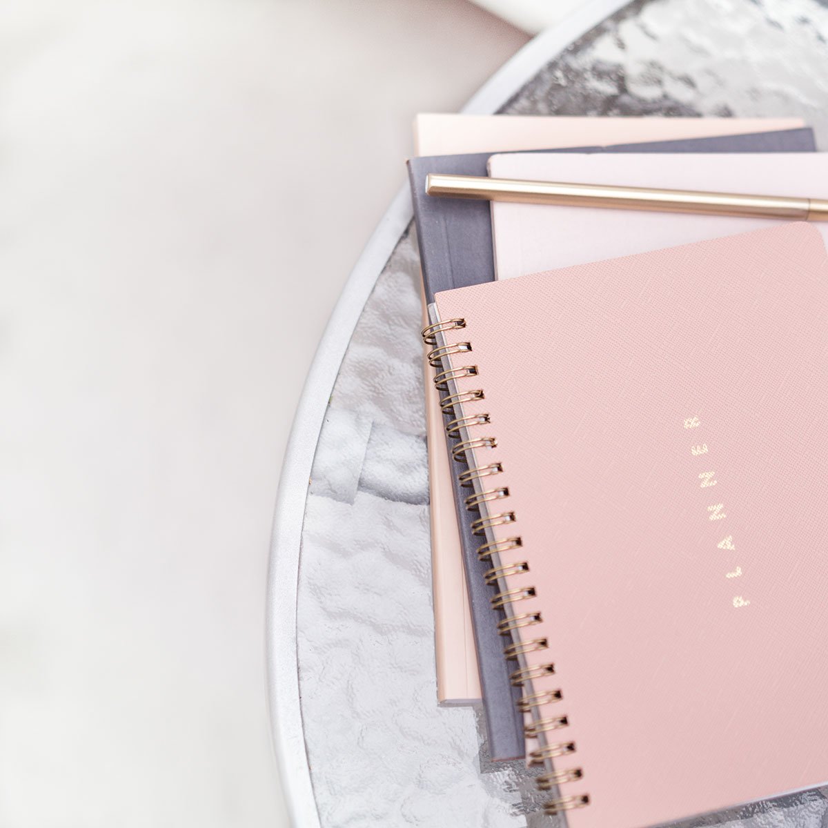 A stack of pink and grey journals and planners used in therapy