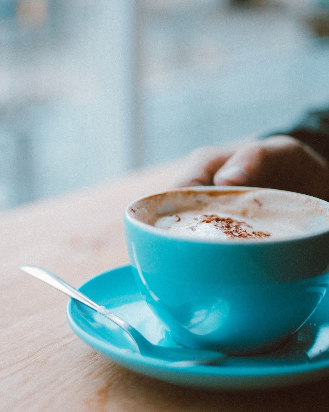 A blue coffee cup on a wooden table of someone having counselling after separation and divorce.