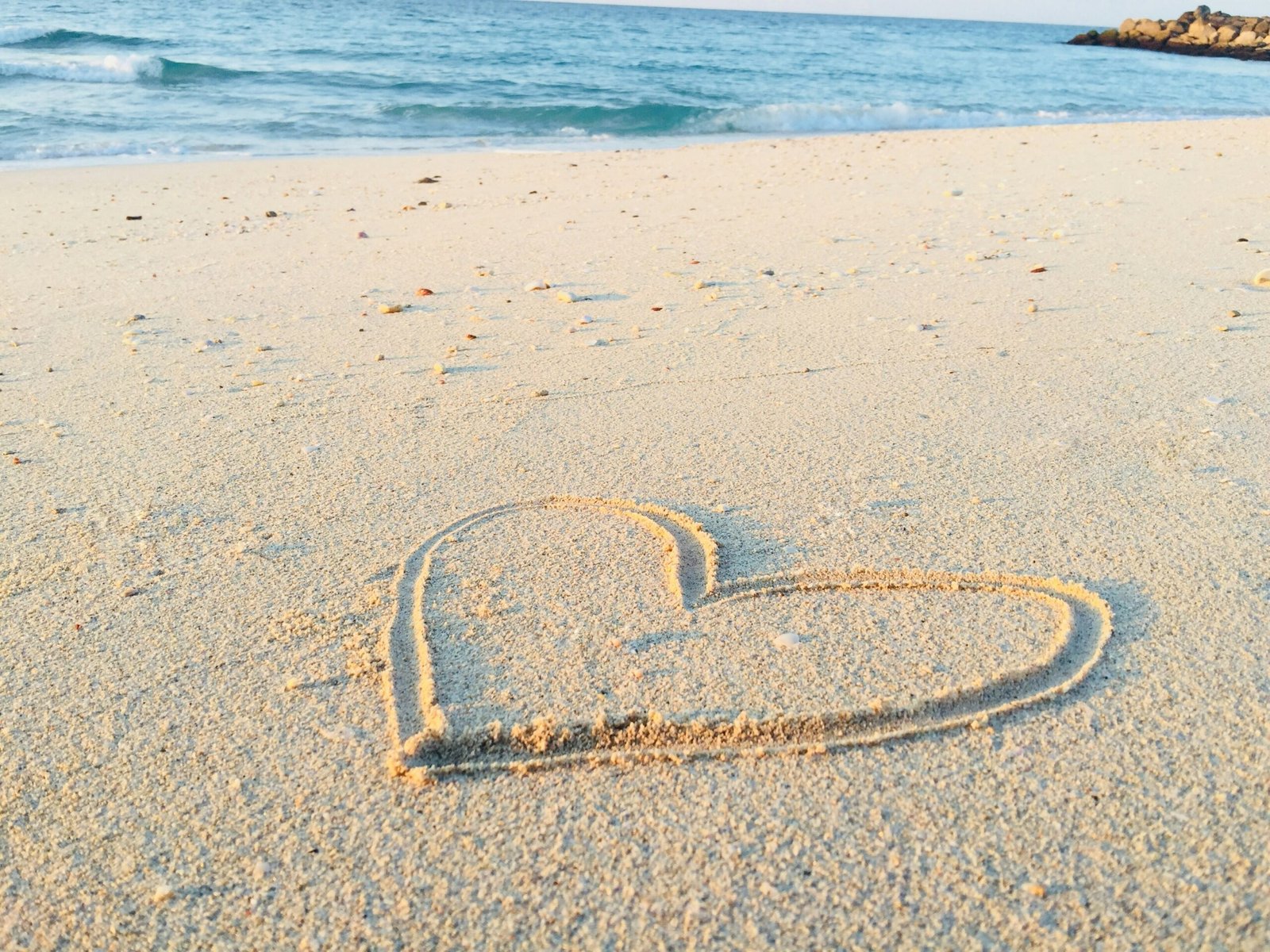 The ocean and beach at Quinns Rocks with a heart drawn in the sand representing healing at The Beach Haven counselling in Clarkson