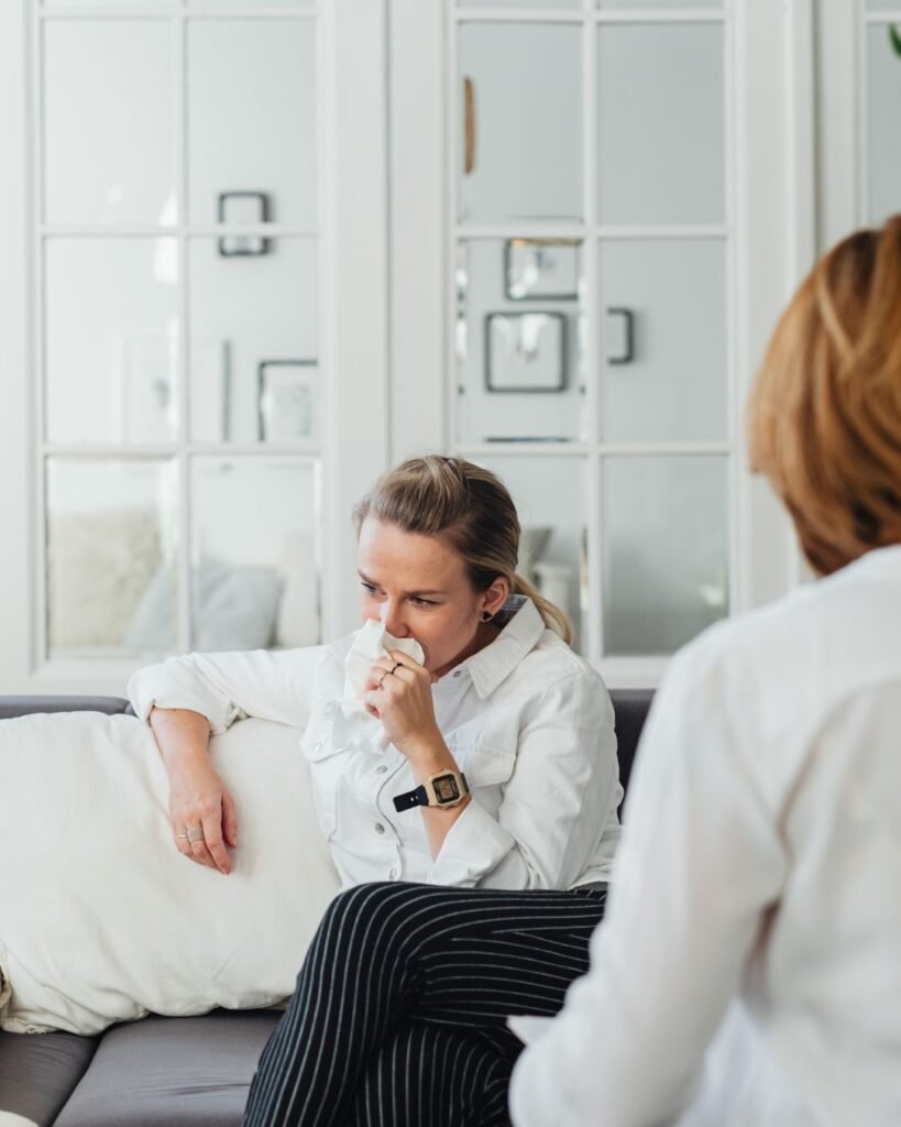 Woman on a couch talking to a counsellor depicting Trauma Counselling