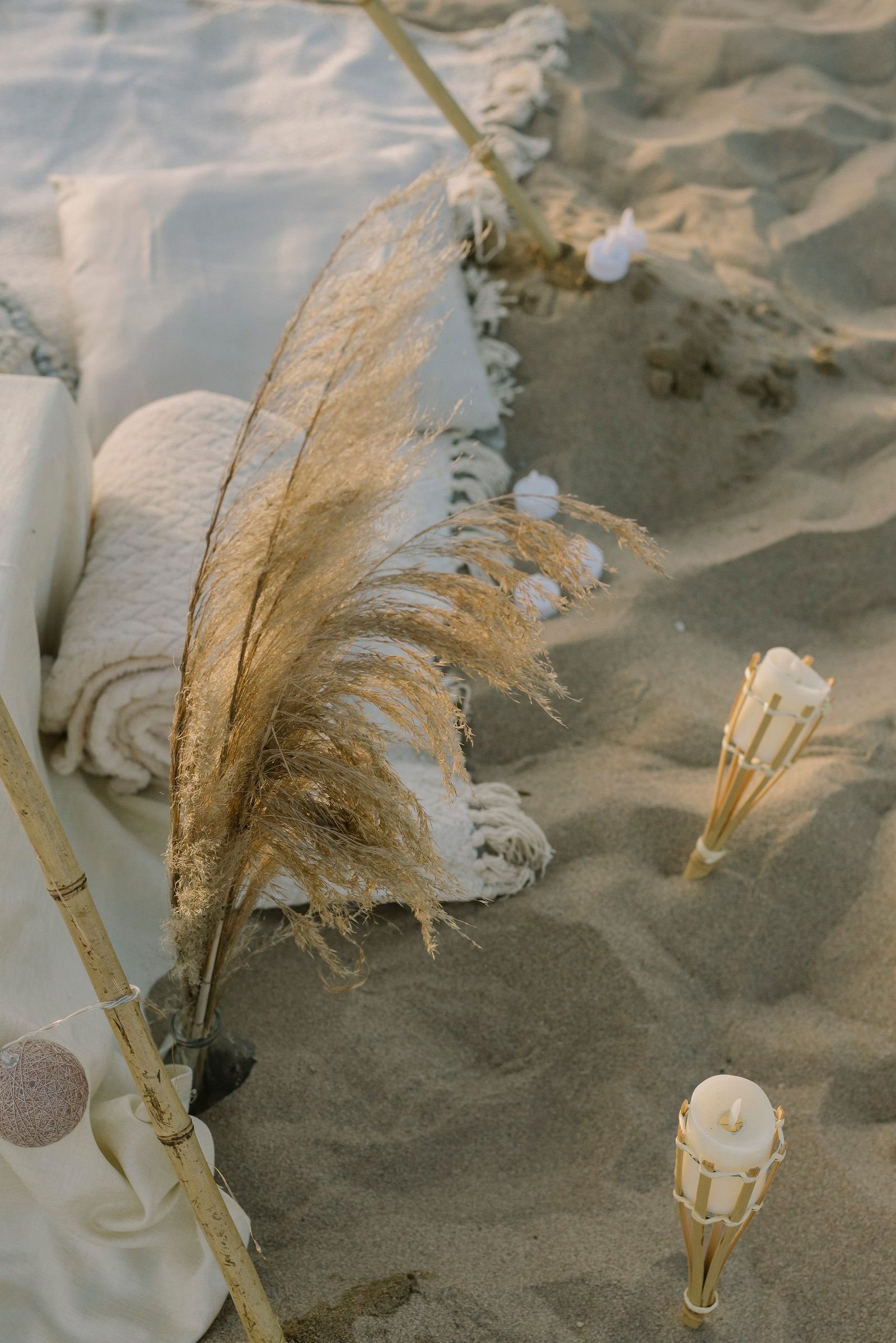 Beach with blankets, flowers and candles set up as part of an end-of-life memorial