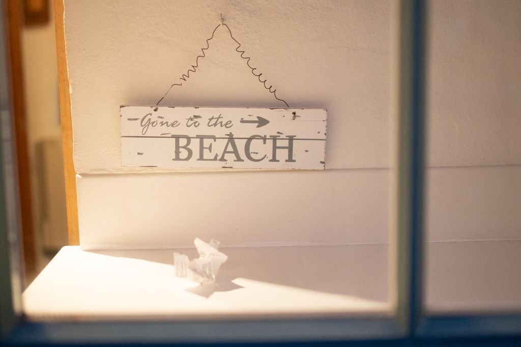 Wooden sign reading 'Gone to the Beach' hangs inside the Beach Haven counselling in Clarkson